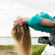 Woman hanging her head out of a car window