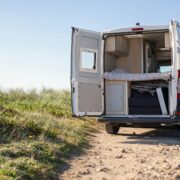 Campervan with doors open on a dirt road