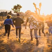 Group of people running through trees in the desert