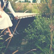 Close up of bride and grooms feet sitting on a wooden walkway