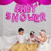 Pink baby shower sign and kids